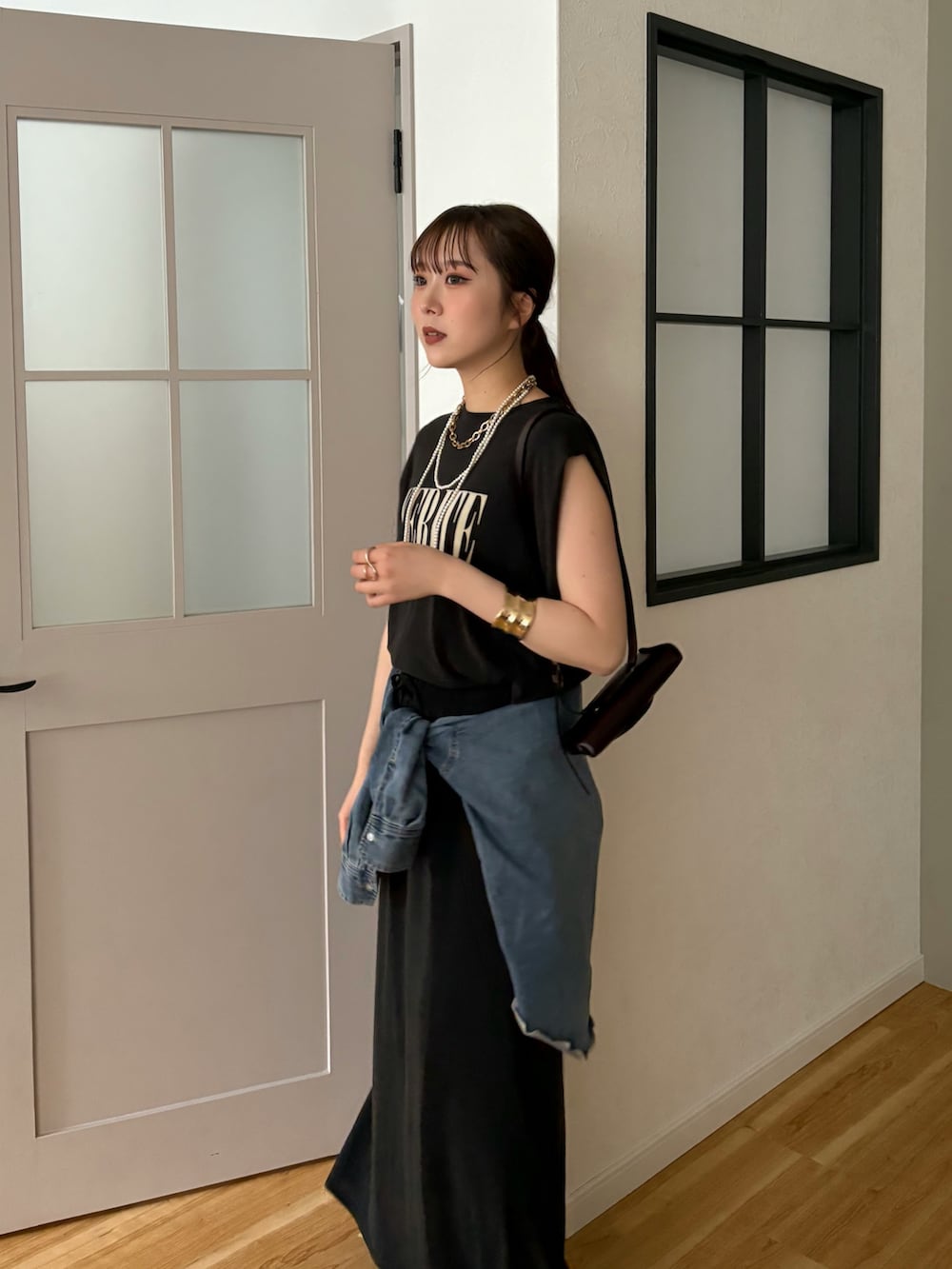 ブラック系のTシャツ/カットソー、ブラック系のスカート、ブルー系のシャツ/ブラウスを着用したレディースの春コーディネートの3枚目の写真