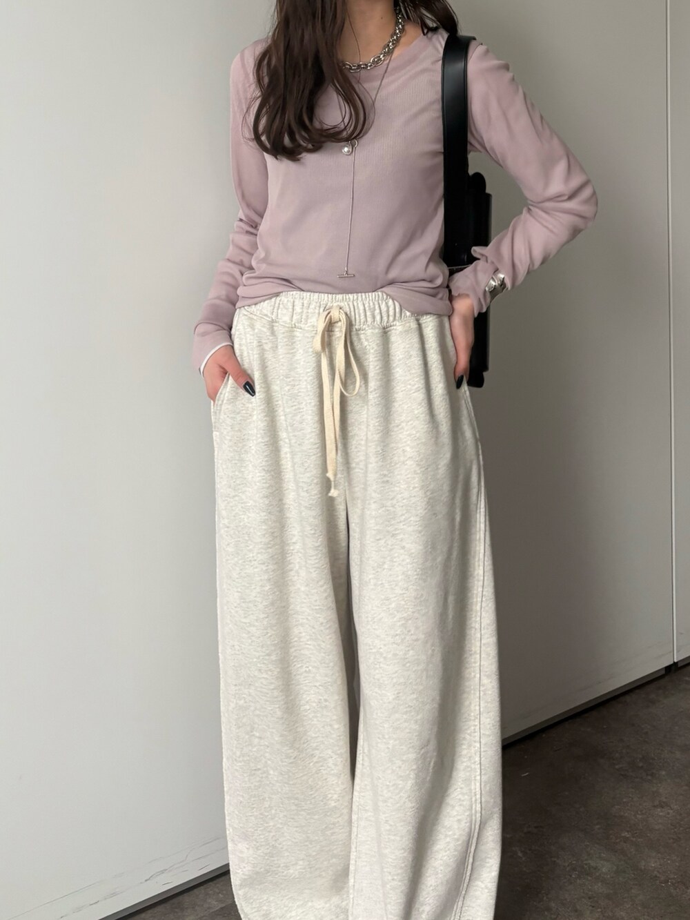 グレー系のその他パンツ、グレー系のTシャツ/カットソー、シルバー系のネックレスを着用したレディースの冬コーディネートの5枚目の写真