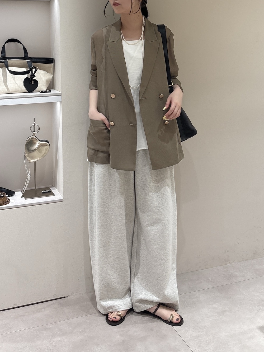 ベージュ系のその他パンツ、ブラウン系のテーラードジャケット、ホワイト系のキャミソールを着用したレディースの春コーディネートの2枚目の写真