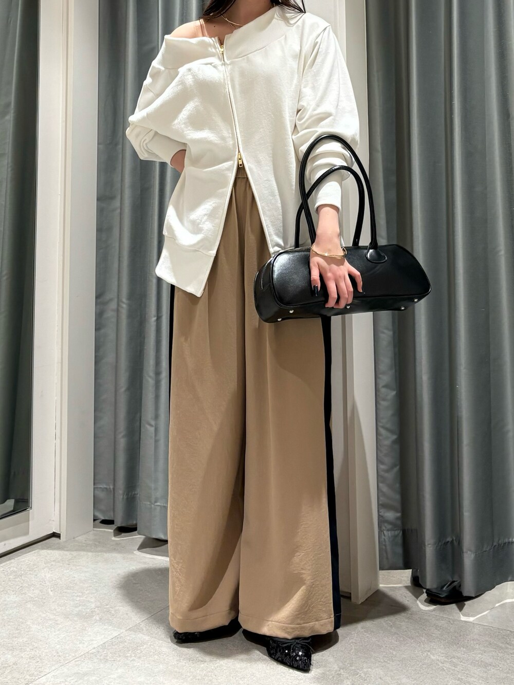 ベージュ系のその他パンツ、ホワイト系のTシャツ/カットソー、ブラック系のショルダーバッグを着用したレディースの冬コーディネートの6枚目の写真