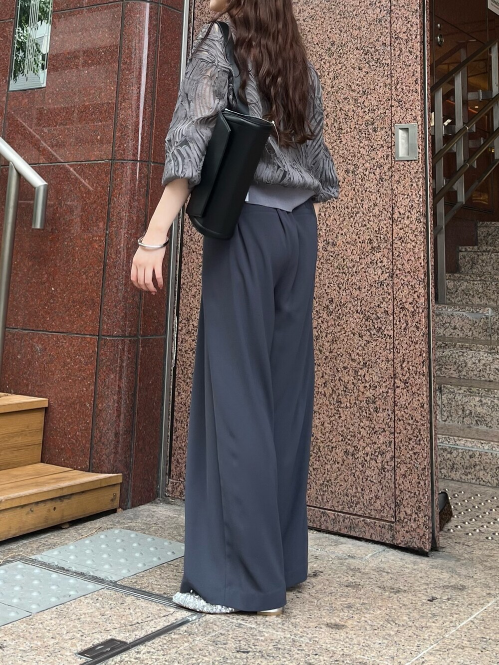グレー系のスラックス、シルバー系のパンプス、ブラック系のショルダーバッグを着用したレディースの秋コーディネートの5枚目の写真