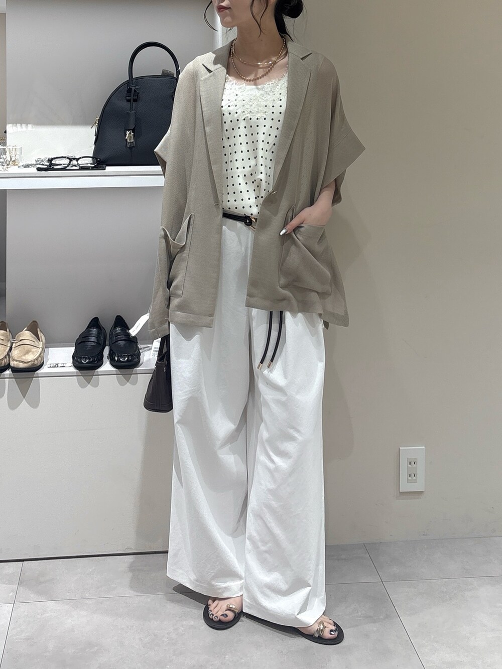 ホワイト系のその他パンツ、ベージュ系のテーラードジャケット、ブラウン系のショルダーバッグを着用したレディースの夏コーディネートの2枚目の写真