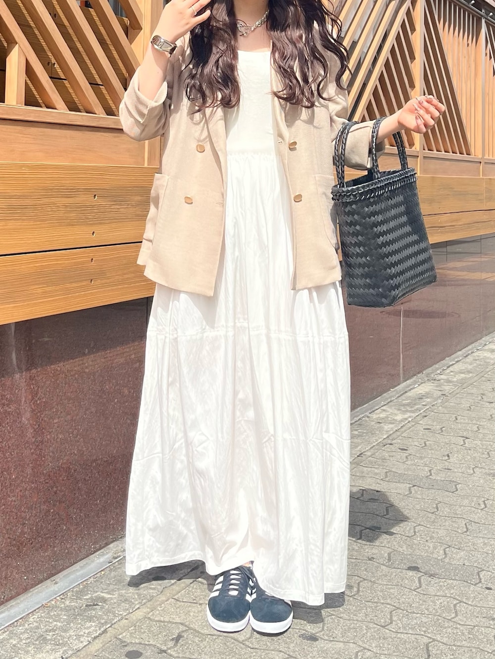 ベージュ系のテーラードジャケット、ホワイト系のワンピース、ブラック系のかごバッグを着用したレディースの夏コーディネートの6枚目の写真