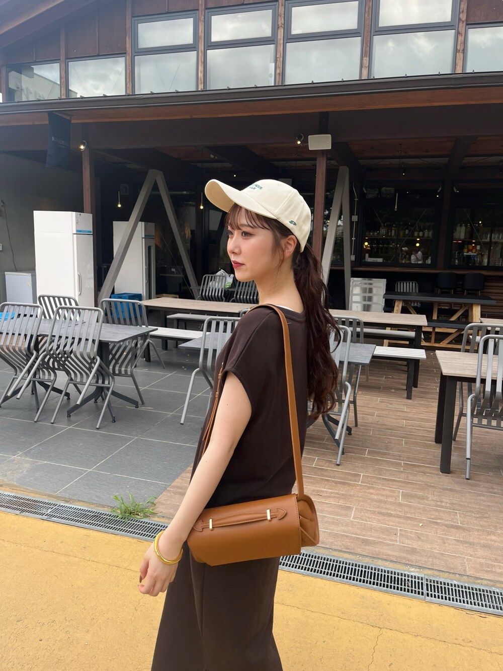 ブラウン系のワンピース、ブラック系のシューズ、ブラウン系のショルダーバッグを着用したレディースの秋コーディネートの5枚目の写真