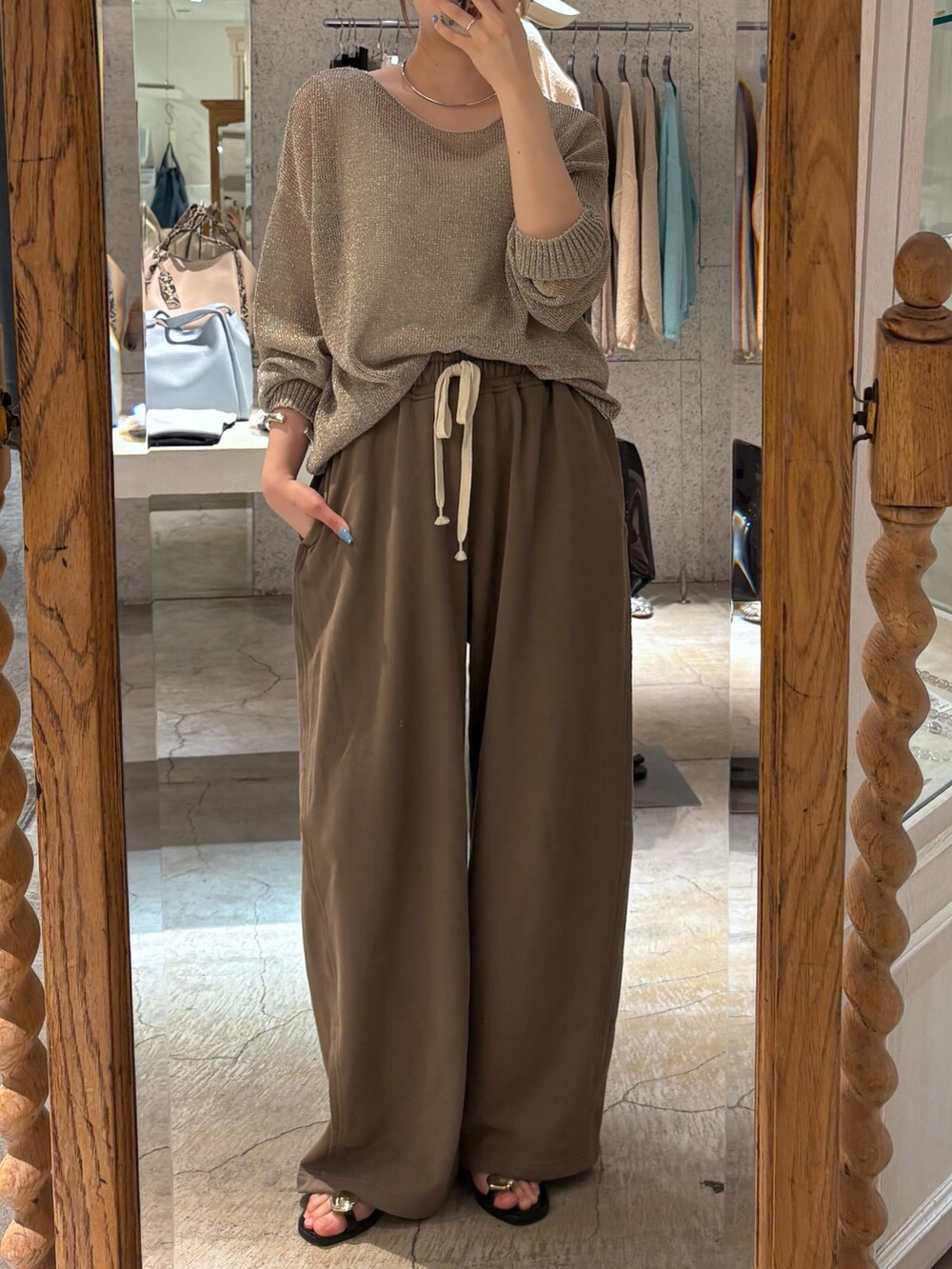 ブラウン系のその他パンツ、ゴールド系のニット/セーター、シルバー系のサンダルを着用したレディースの夏コーディネートの2枚目の写真