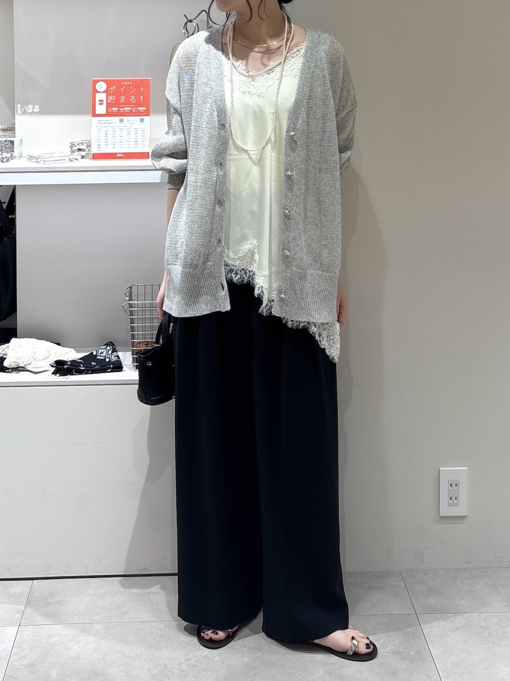 ホワイト系のシャツ/ブラウス、グレー系のカーディガン/ボレロ、ブラック系のスラックスを着用したレディースの夏コーディネートの2枚目の写真