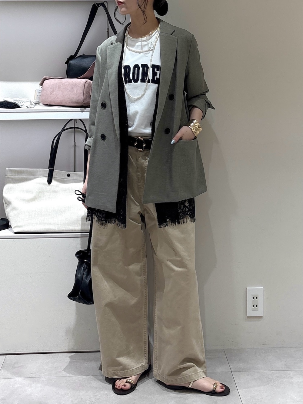 ベージュ系のチノパンツ、ブラック系のトートバッグ、ブラック系のベストを着用したレディースの秋コーディネートの2枚目の写真