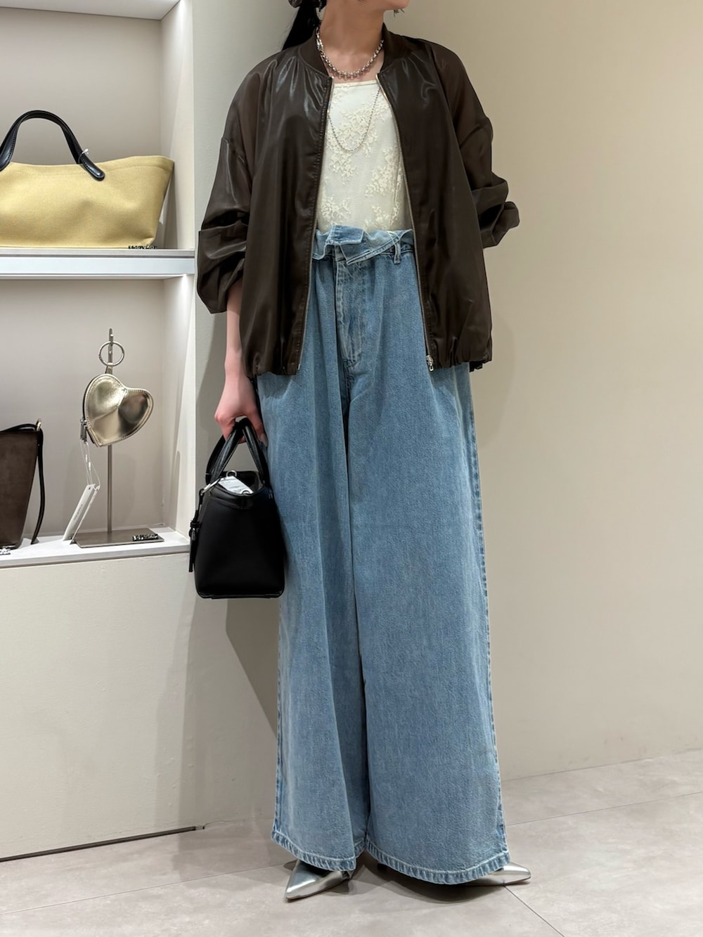 ブラウン系のその他アウター、ブルー系のデニムパンツ、ブラック系のショルダーバッグを着用したレディースの春コーディネートの2枚目の写真