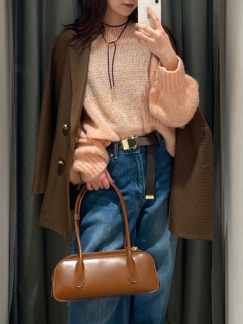 ピンク系のニット/セーター、ブラウン系のテーラードジャケット、ブルー系のデニムパンツを着用したレディースの秋コーディネートの2枚目の写真