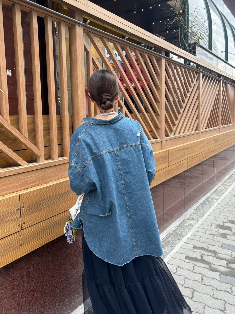 ブルー系のスカート、ブラウン系のブーツ、ホワイト系のショルダーバッグを着用したレディースの冬コーディネートの5枚目の写真