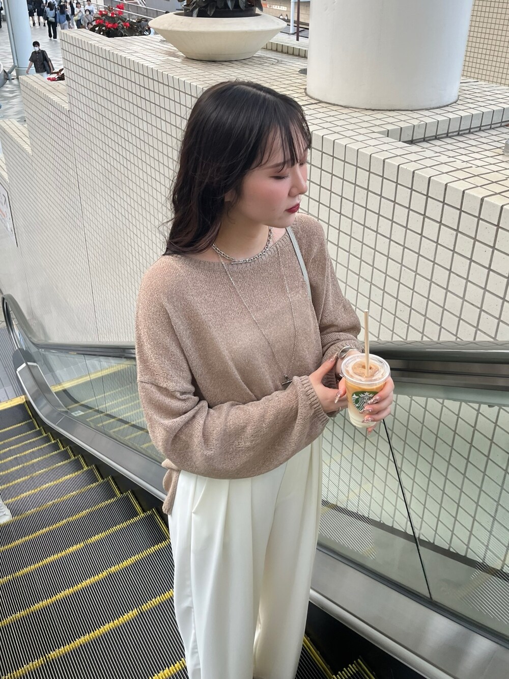 ブラウン系のニット/セーター、ホワイト系のスラックス、シルバー系のパンプスを着用したレディースの夏コーディネートの6枚目の写真