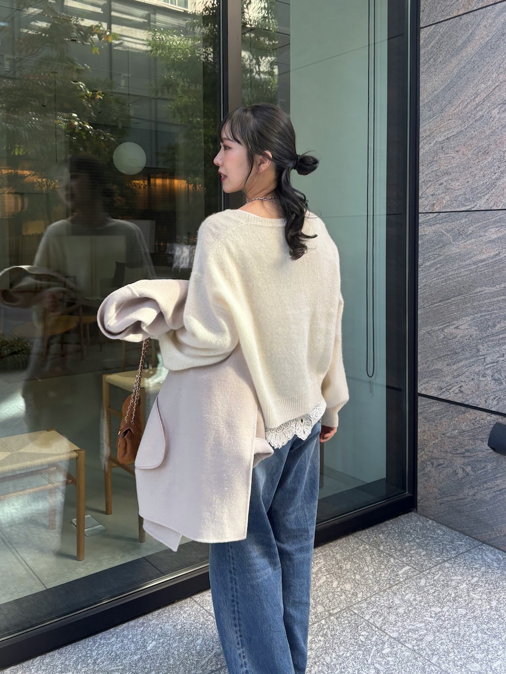 ブルー系のデニムパンツ、イエロー系のショルダーバッグ、ベージュ系のその他アウターを着用したレディースの秋コーディネートの2枚目の写真