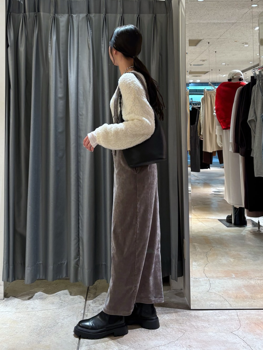 ベージュ系のワンピース、ブラック系のブーツ、ホワイト系のTシャツ/カットソーを着用したレディースの冬コーディネートの2枚目の写真