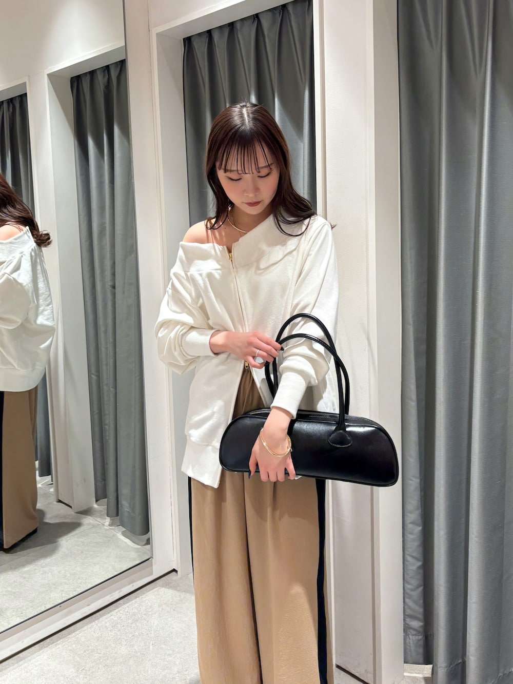 ベージュ系のその他パンツ、ホワイト系のTシャツ/カットソー、ブラック系のショルダーバッグを着用したレディースの冬コーディネートの2枚目の写真