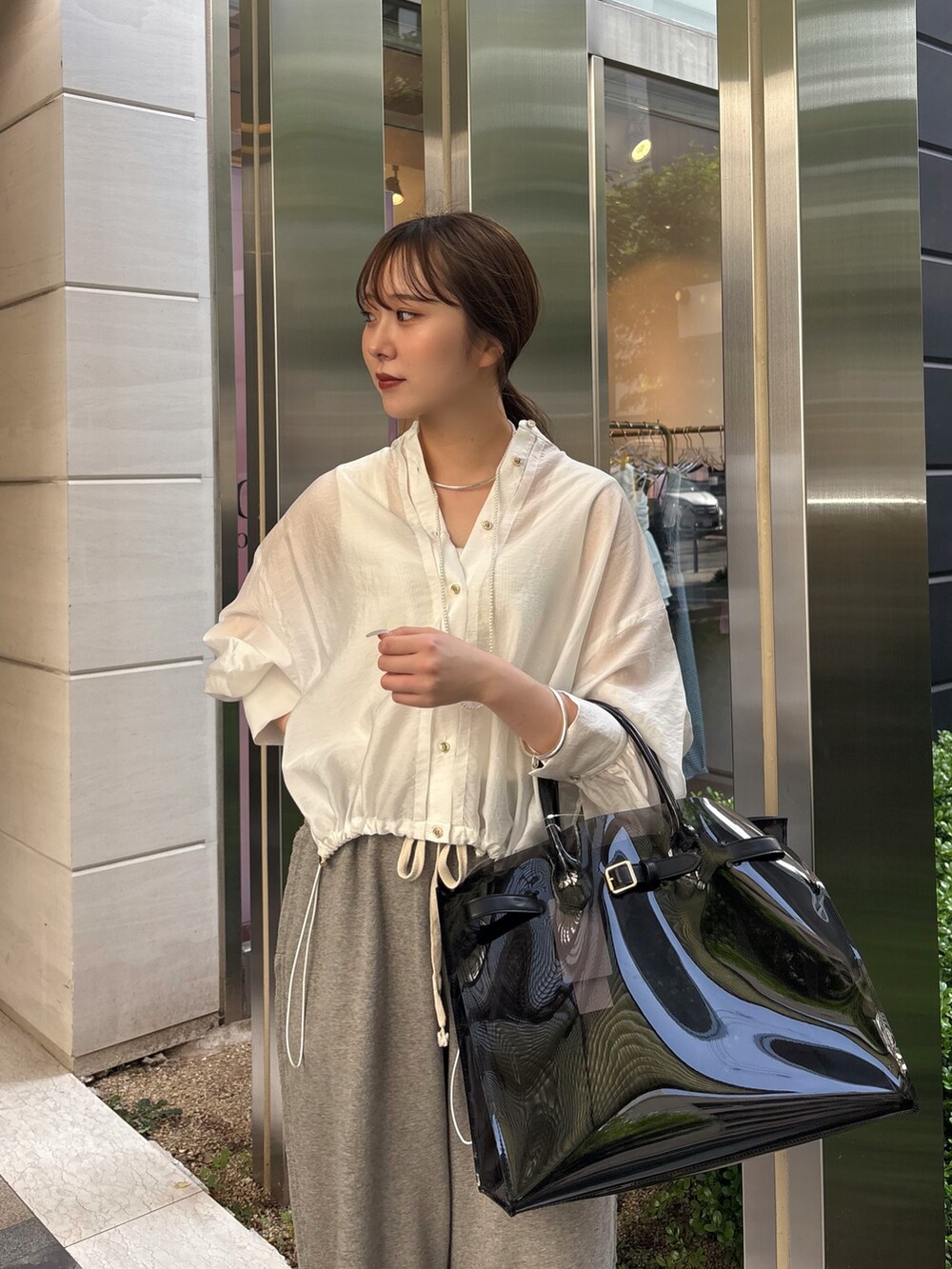 グレー系のその他パンツ、ブラック系のショルダーバッグ、ホワイト系のシャツ/ブラウスを着用したレディースの春コーディネートの3枚目の写真