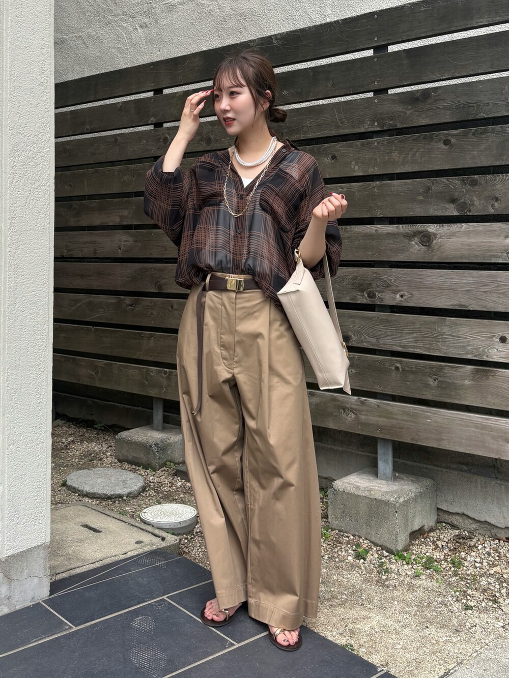 ブラック系のシャツ/ブラウス、ベージュ系のその他パンツ、ホワイト系のショルダーバッグを着用したレディースの夏コーディネートの2枚目の写真