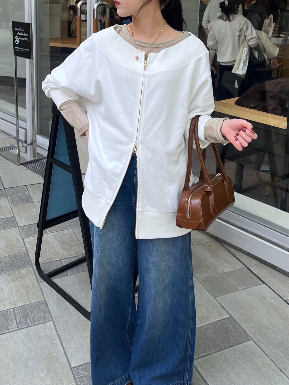 ブルー系のデニムパンツ、ベージュ系のその他アウター、ホワイト系のTシャツ/カットソーを着用したレディースの冬コーディネートの5枚目の写真