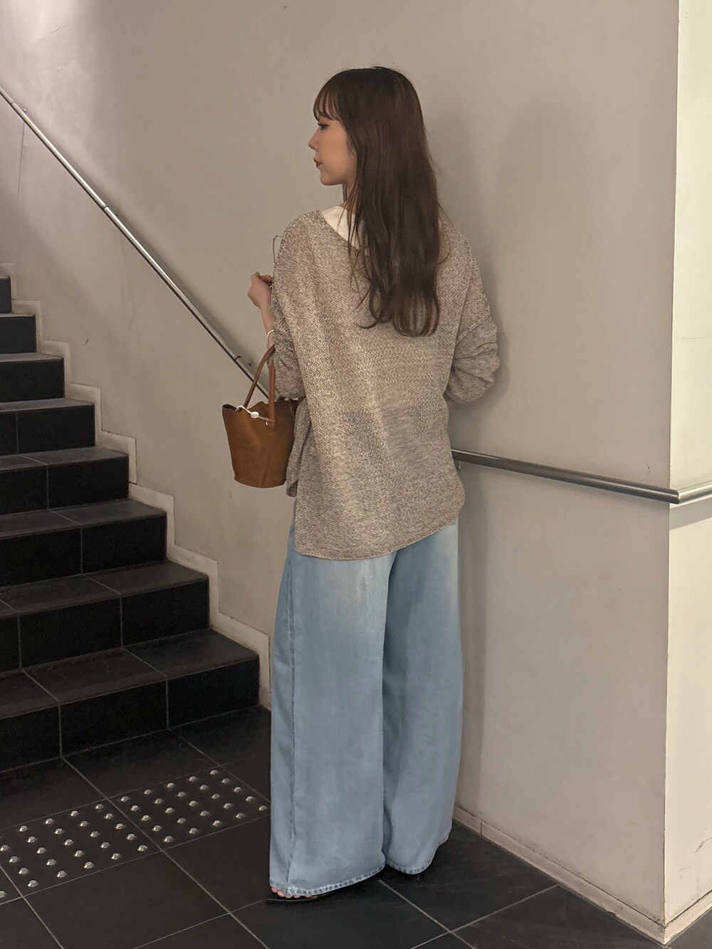 ブルー系のデニムパンツ、ブラック系のサンダル、ベージュ系のニット/セーターを着用したレディースの夏コーディネートの3枚目の写真