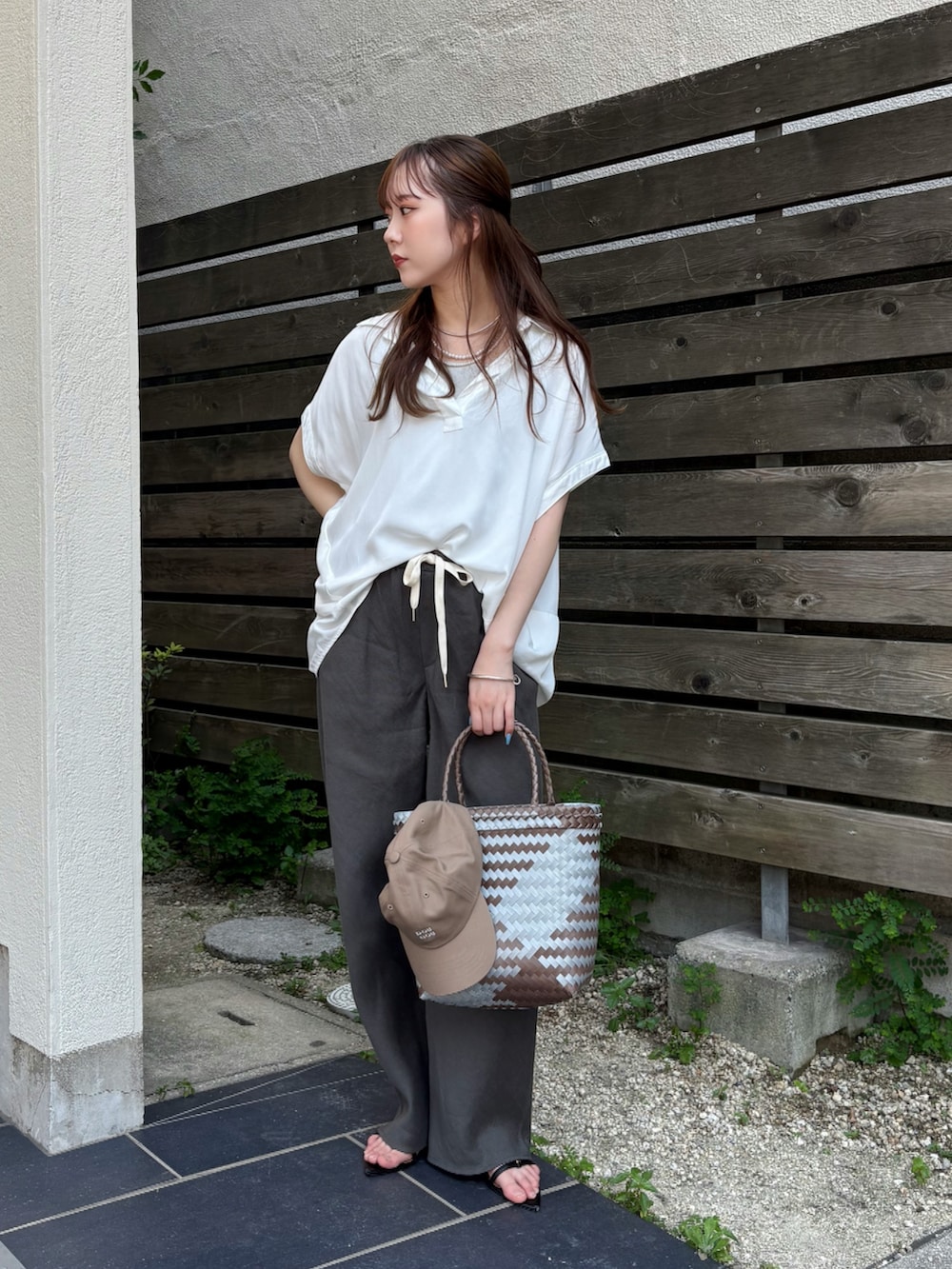 グレー系のその他パンツ、ブラック系のサンダル、ホワイト系のシャツ/ブラウスを着用したレディースの夏コーディネートの2枚目の写真