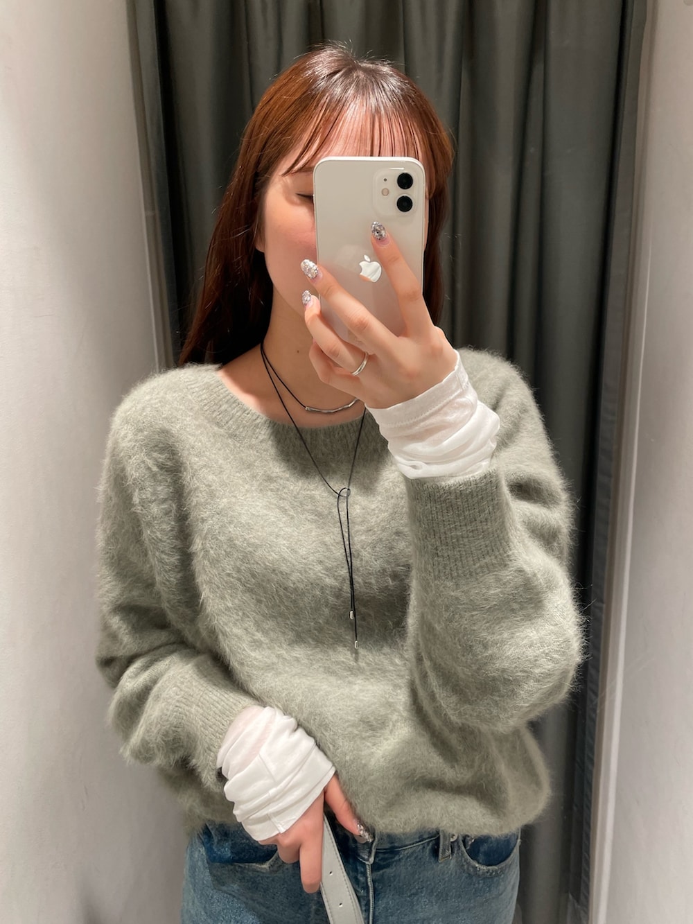 ブルー系のデニムパンツ、ブラック系のその他アウター、グリーン系のニット/セーターを着用したレディースの秋コーディネートの5枚目の写真