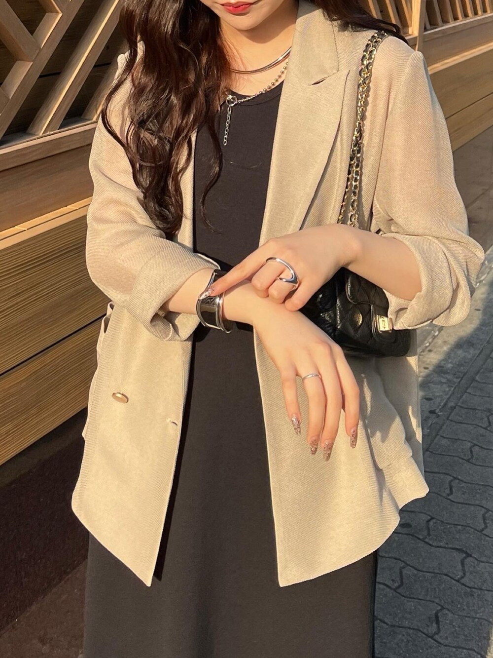 ブラック系のワンピース/ドレス、ベージュ系のテーラードジャケット、ブラック系のショルダーバッグを着用したレディースの夏コーディネートの3枚目の写真