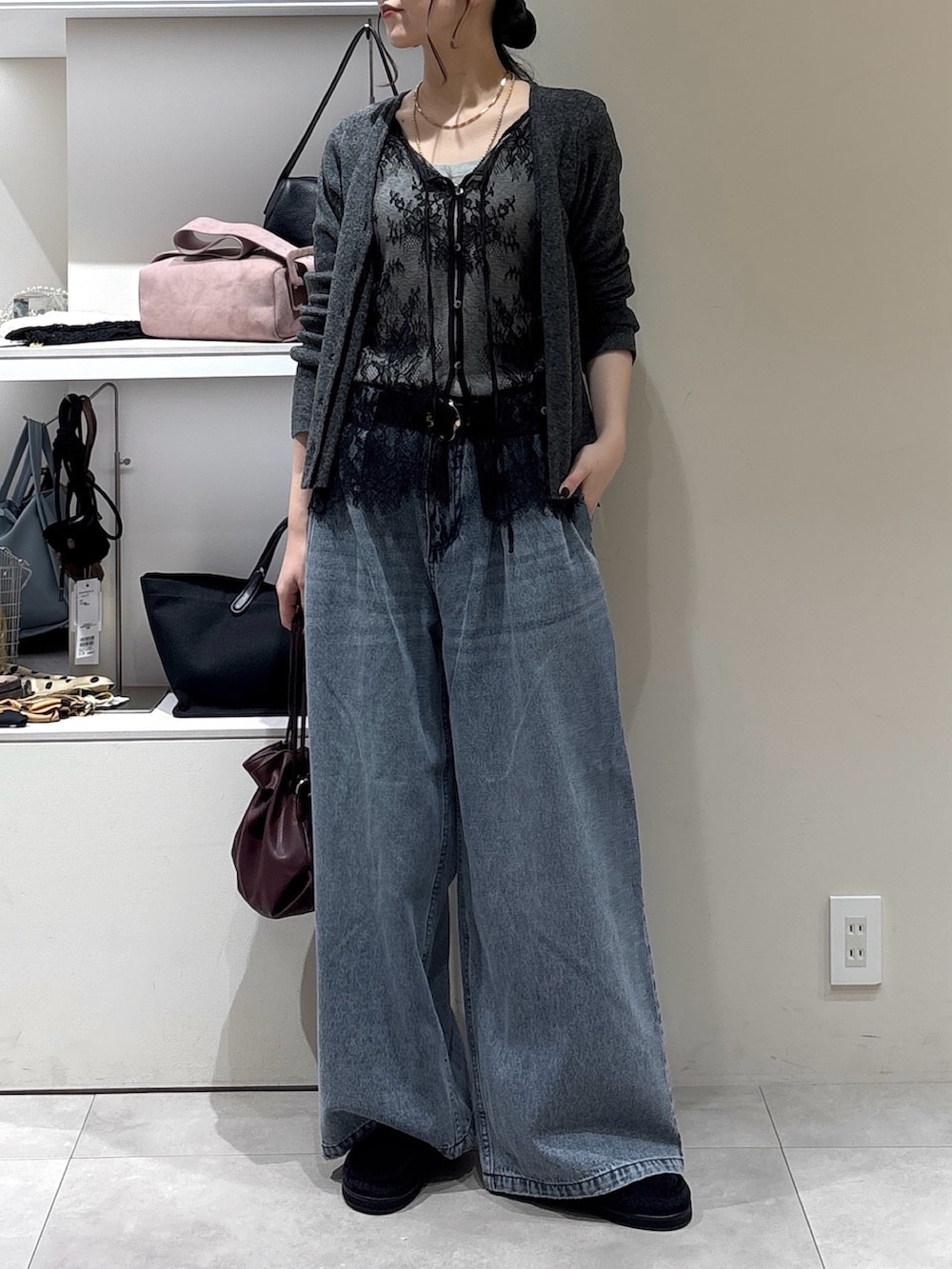 ブラック系のその他シューズ、ブルー系のデニムパンツ、レッド系のトートバッグを着用したレディースの秋コーディネートの2枚目の写真