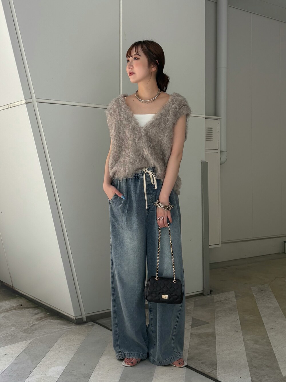 ベージュ系のニット/セーター、ブルー系のその他パンツ、ブラック系のショルダーバッグを着用したレディースの夏コーディネートの3枚目の写真