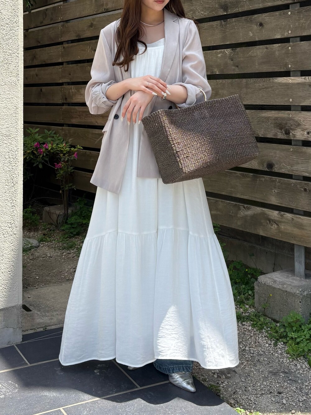 ブルー系のデニムパンツ、グレー系のワンピース、ベージュ系のテーラードジャケットを着用したレディースの春コーディネートの6枚目の写真