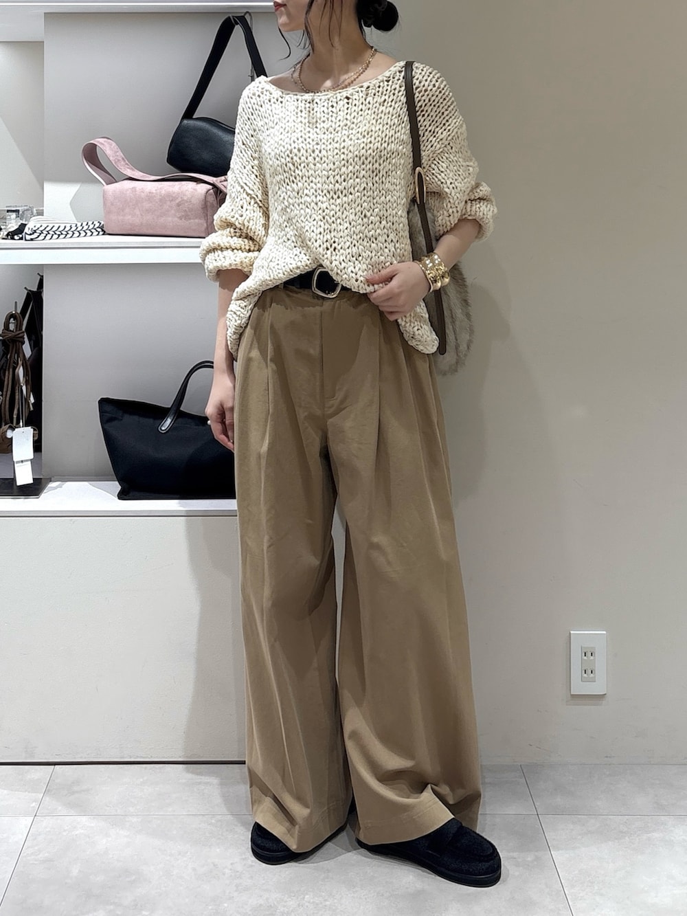ブラック系のその他シューズ、ベージュ系のその他パンツ、ホワイト系のトートバッグを着用したレディースの秋コーディネートの2枚目の写真