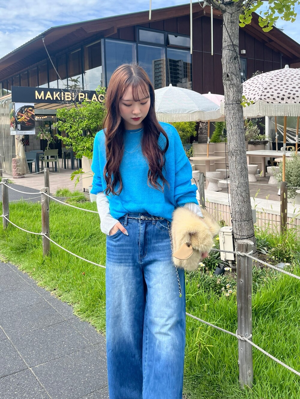 ブルー系のニット/セーター、シルバー系のTシャツ/カットソー、イエロー系のショルダーバッグを着用したレディースの秋コーディネートの4枚目の写真