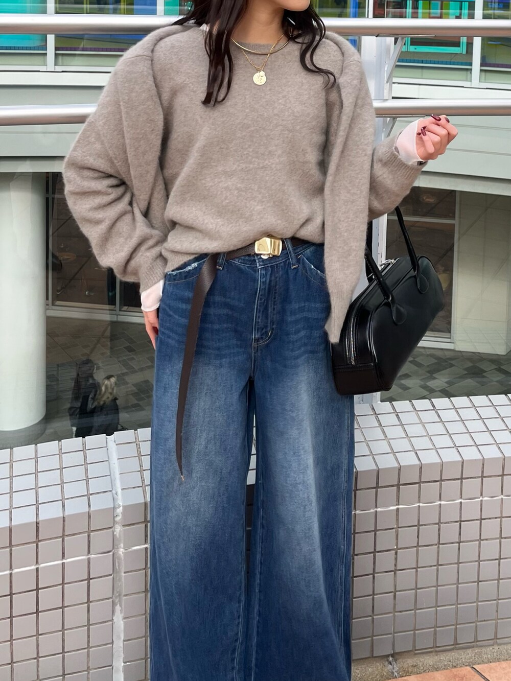 ブルー系のデニムパンツ、ブラウン系のニット/セーター、ブラウン系のカーディガン/ボレロを着用したレディースの冬コーディネートの4枚目の写真