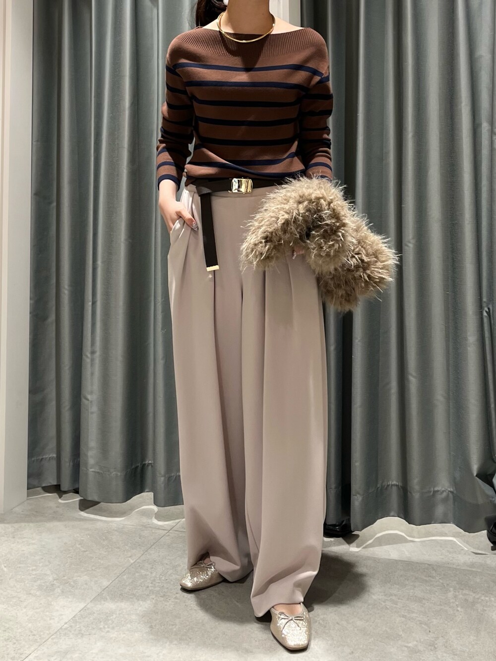 ベージュ系のショルダーバッグ、ベージュ系のスラックス、ブラウン系のニット/セーターを着用したレディースの秋コーディネートの3枚目の写真