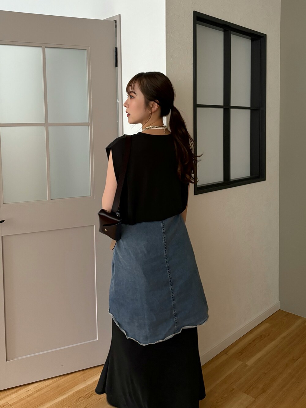 ブラック系のTシャツ/カットソー、ブラック系のスカート、ブルー系のシャツ/ブラウスを着用したレディースの春コーディネートの4枚目の写真