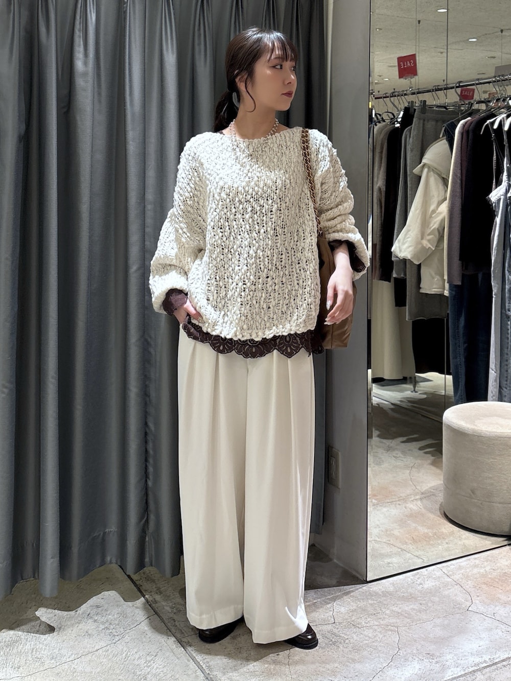 ホワイト系のニット/セーター、ホワイト系のスラックス、ブラウン系のシャツ/ブラウスを着用したレディースの冬コーディネートの2枚目の写真