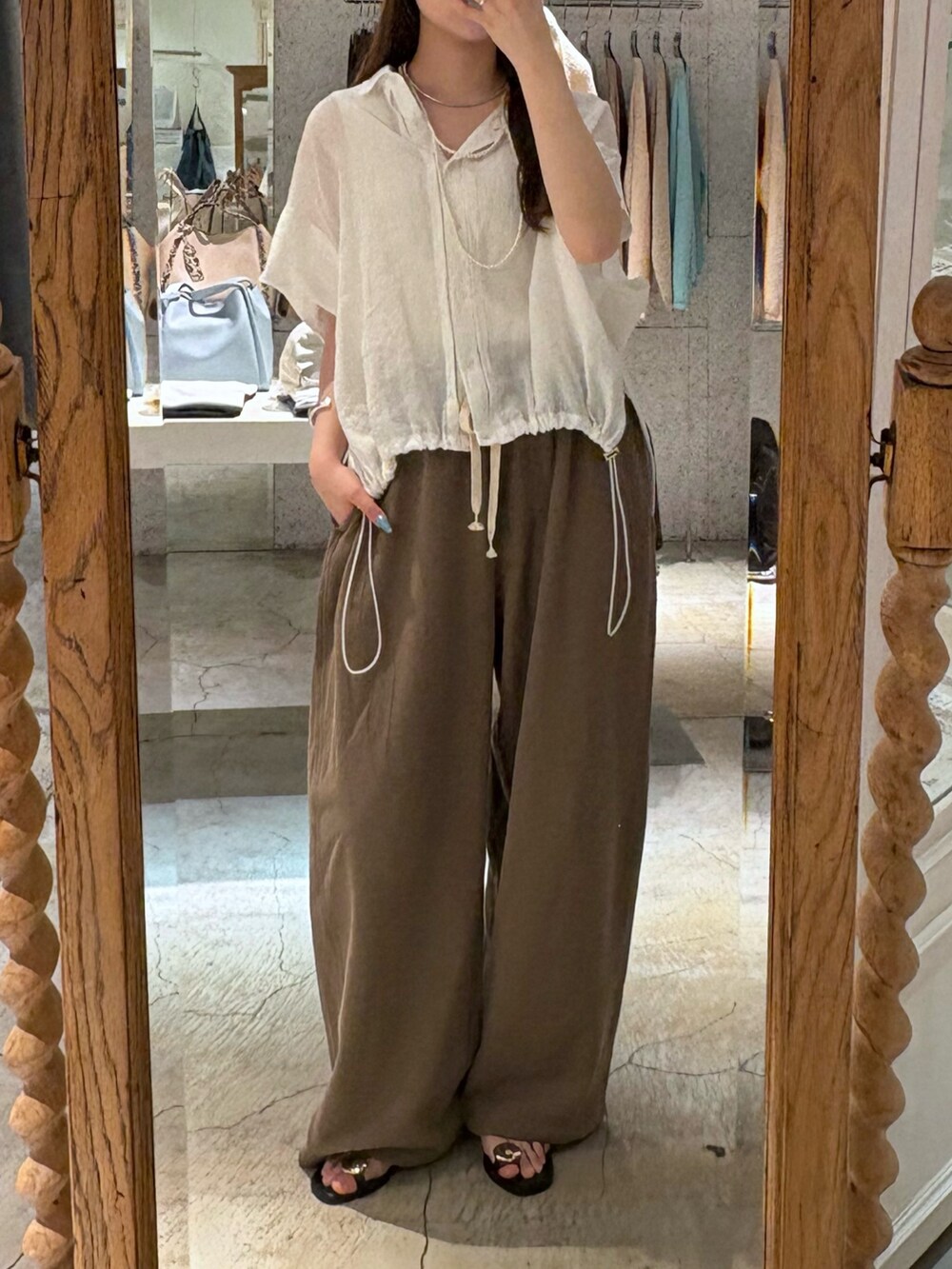 ブラウン系のその他パンツ、ホワイト系のシャツ/ブラウス、シルバー系のサンダルを着用したレディースの夏コーディネートの2枚目の写真