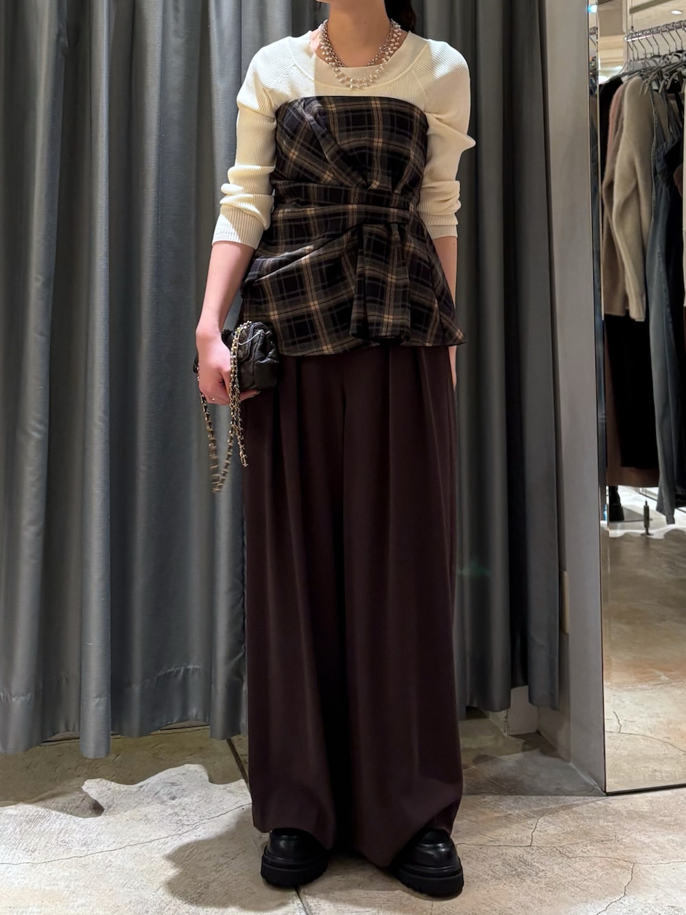 ブラック系のその他トップス、ブラウン系のスラックス、ブラウン系のショルダーバッグを着用したレディースの冬コーディネートの2枚目の写真