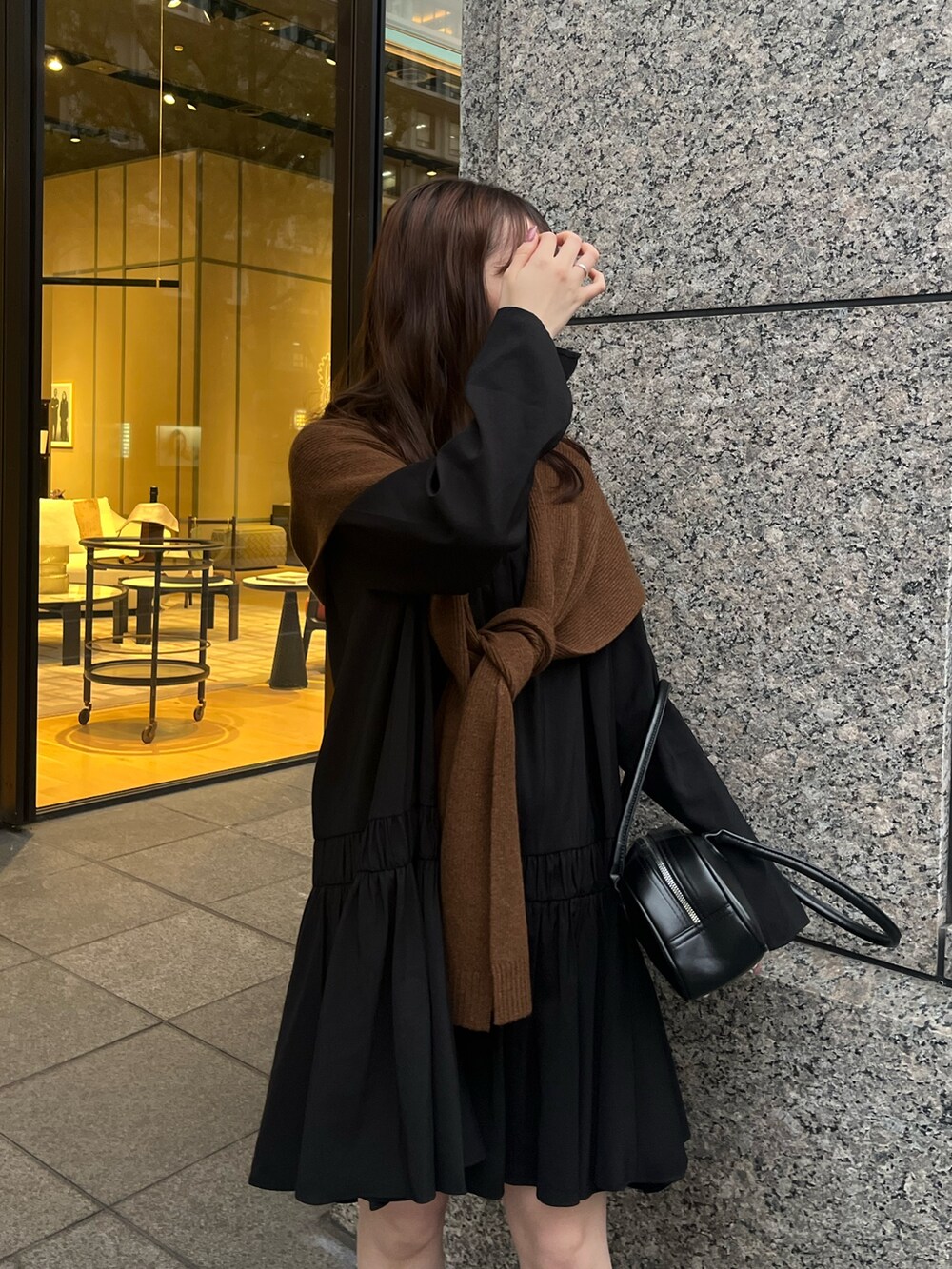 ブラック系のシャツ/ブラウス、ブラック系のショルダーバッグ、ブラウン系のストール/ショールを着用したレディースの秋コーディネートの3枚目の写真