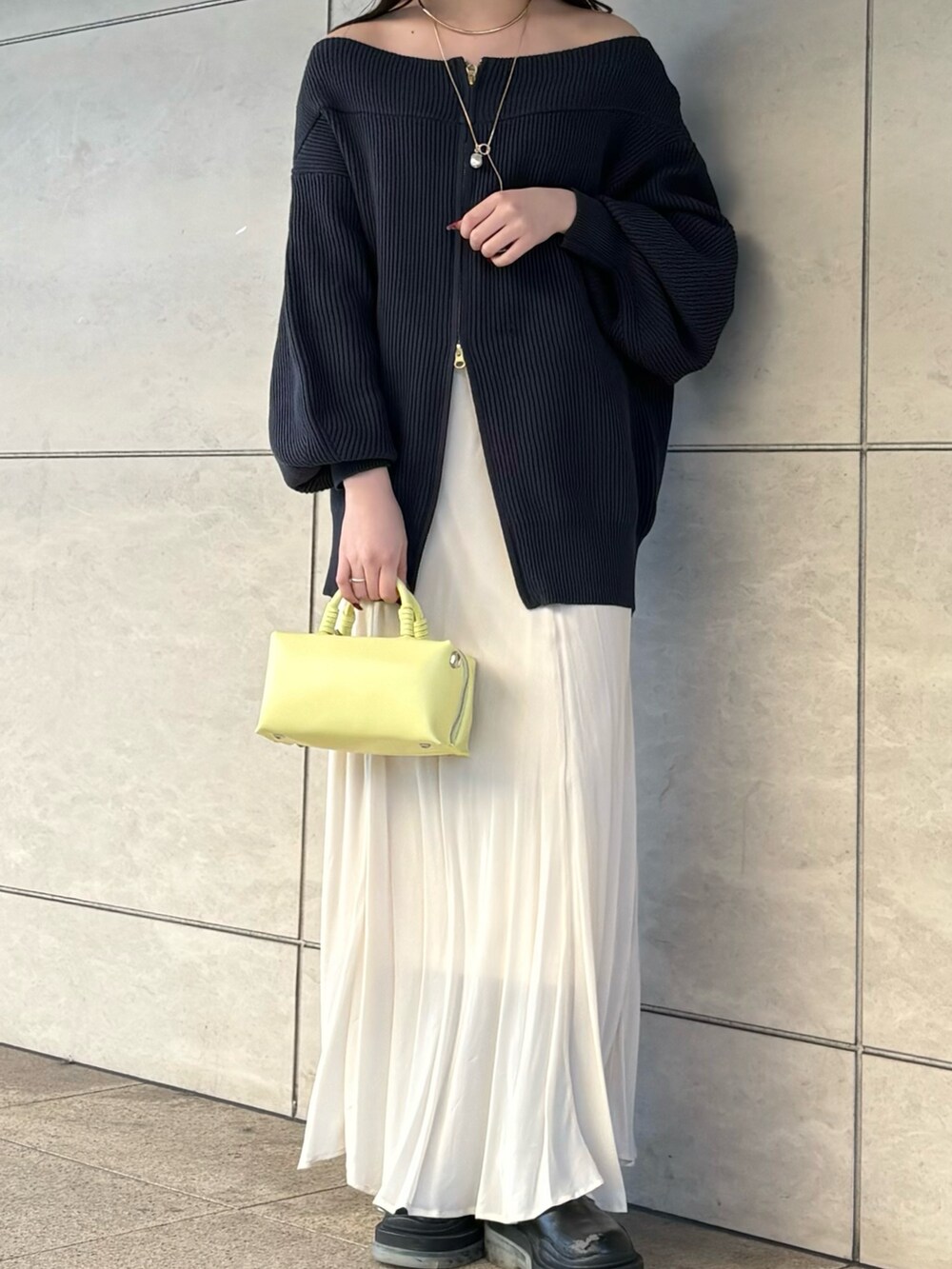 ブルー系のニット/セーター、ホワイト系のスカート、イエロー系のショルダーバッグを着用したレディースの冬コーディネートの3枚目の写真