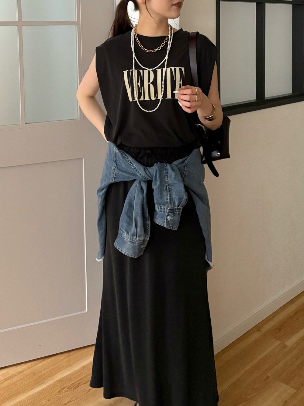 ブラック系のTシャツ/カットソー、ブラック系のスカート、ブルー系のシャツ/ブラウスを着用したレディースの春コーディネートの2枚目の写真