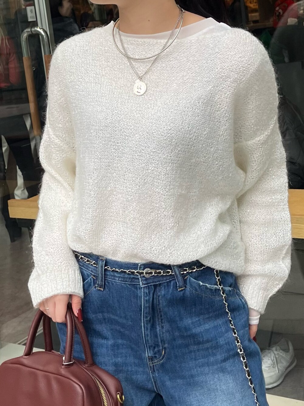 ブルー系のデニムパンツ、ブラウン系のショルダーバッグ、ブルー系のカーディガン/ボレロを着用したレディースの冬コーディネートの6枚目の写真