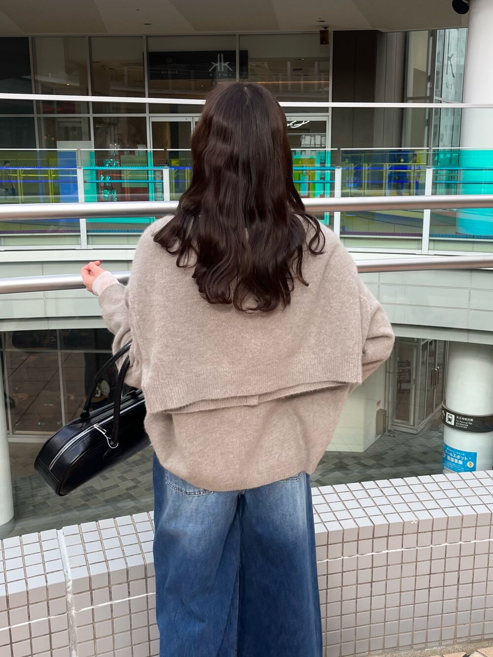 ブルー系のデニムパンツ、ブラウン系のニット/セーター、ブラウン系のカーディガン/ボレロを着用したレディースの冬コーディネートの6枚目の写真