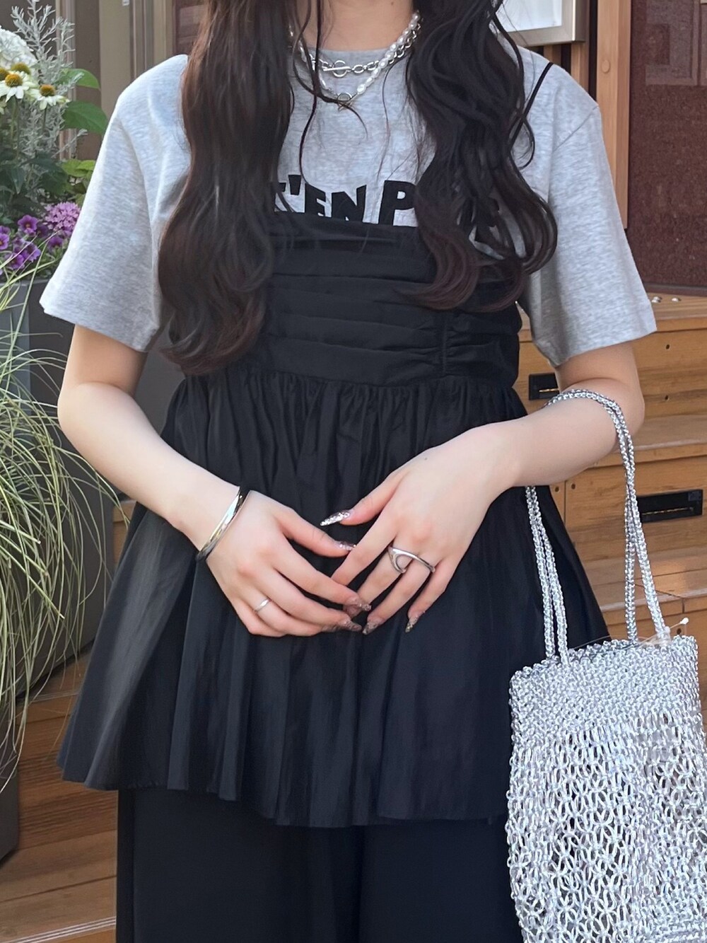 グレー系のTシャツ/カットソー、ブラック系のパンツ、ブラック系のキャミソールを着用したレディースの夏コーディネートの4枚目の写真