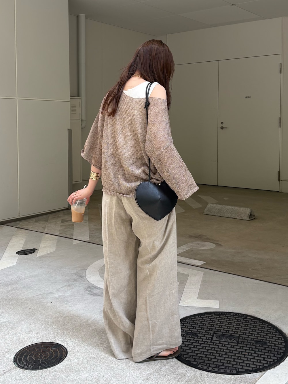 ベージュ系のその他パンツ、ベージュ系のニット/セーター、ブラック系のショルダーバッグを着用したレディースの春コーディネートの5枚目の写真