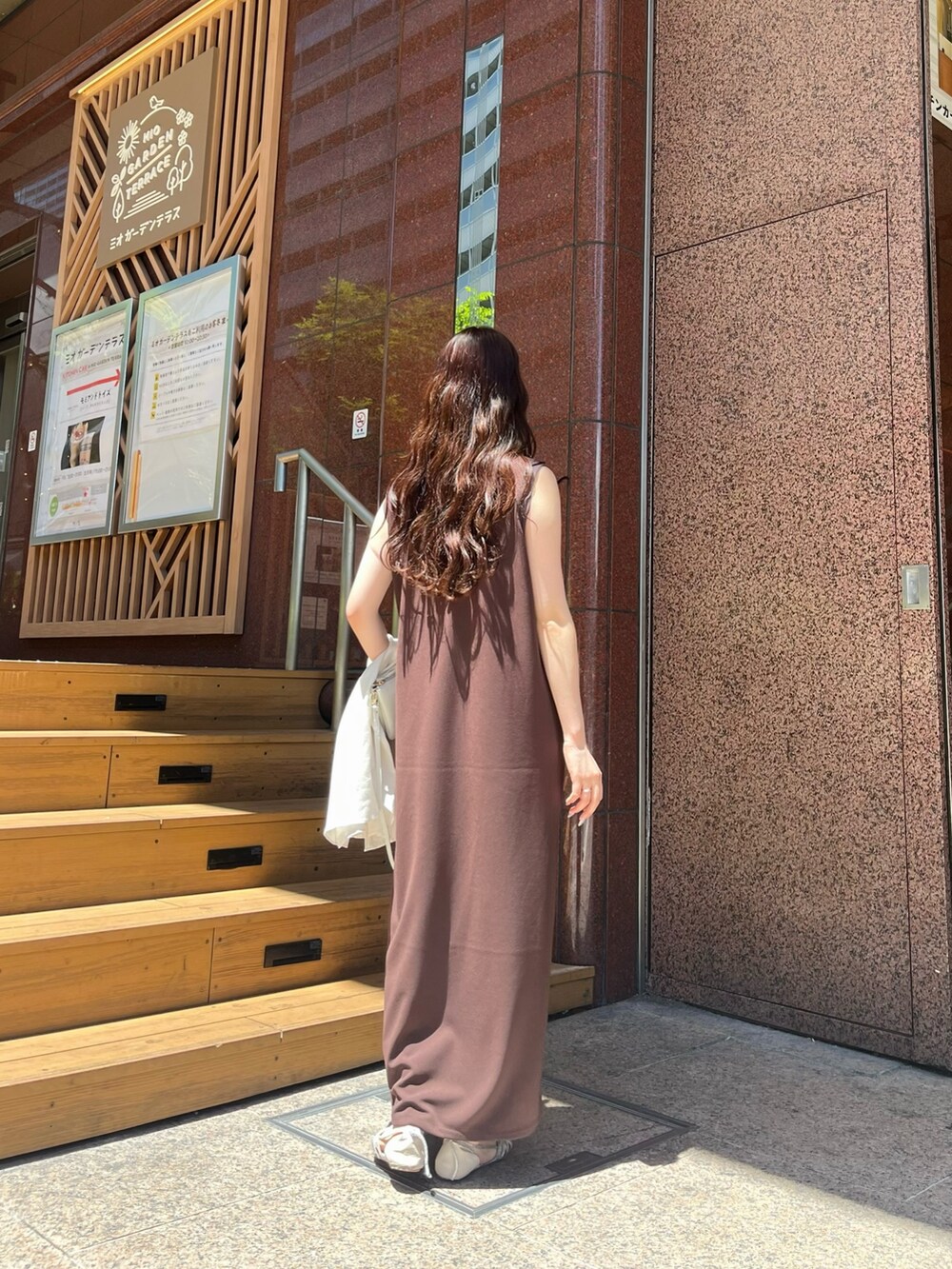 ブラウン系のワンピース、ホワイト系のシャツ/ブラウス、シルバー系のパンプスを着用したレディースの夏コーディネートの4枚目の写真