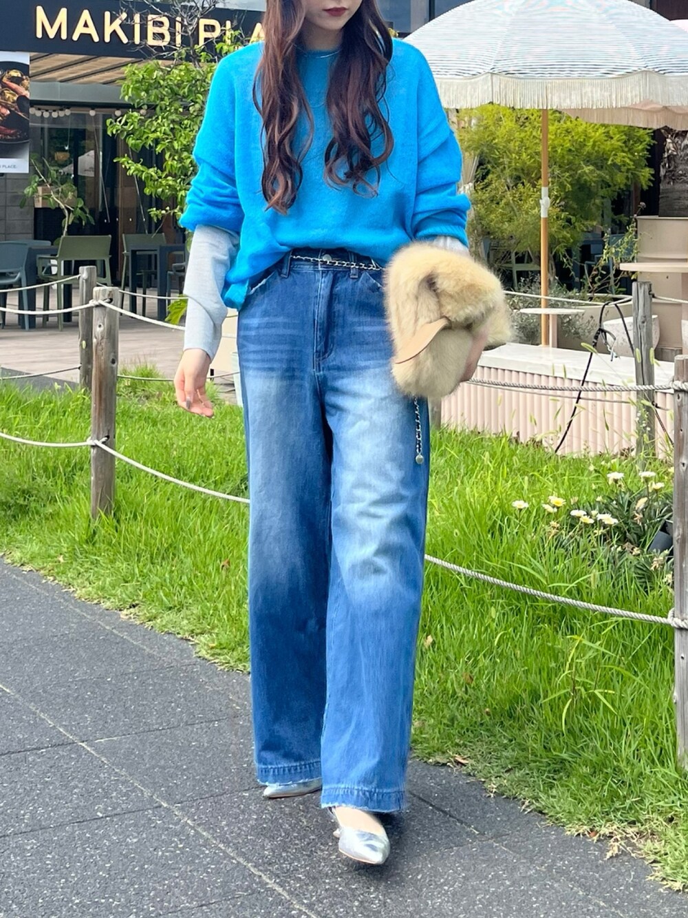 ブルー系のニット/セーター、シルバー系のTシャツ/カットソー、イエロー系のショルダーバッグを着用したレディースの秋コーディネートの6枚目の写真