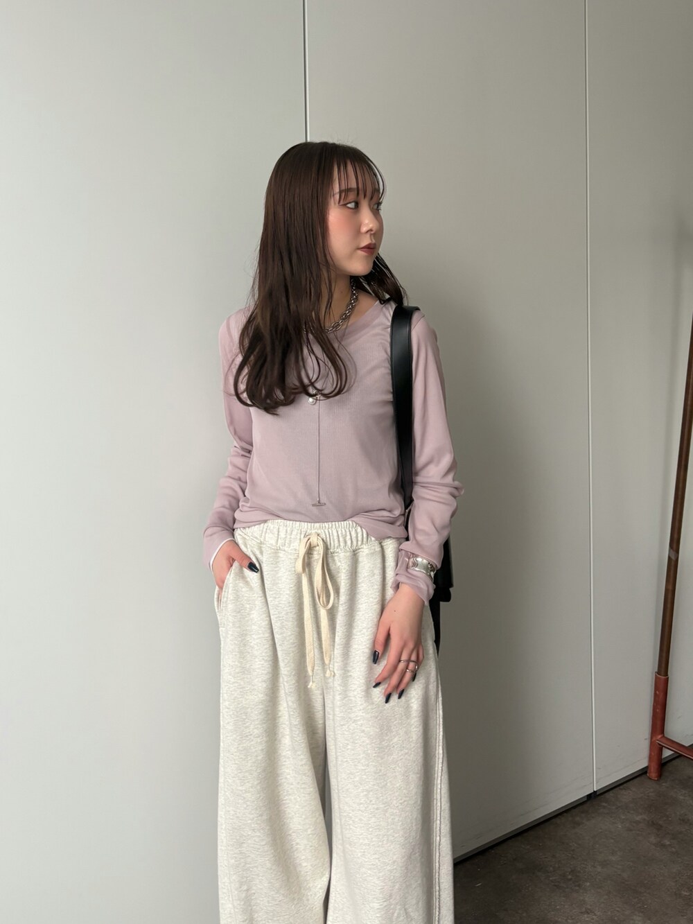 グレー系のその他パンツ、グレー系のTシャツ/カットソー、シルバー系のネックレスを着用したレディースの冬コーディネートの3枚目の写真