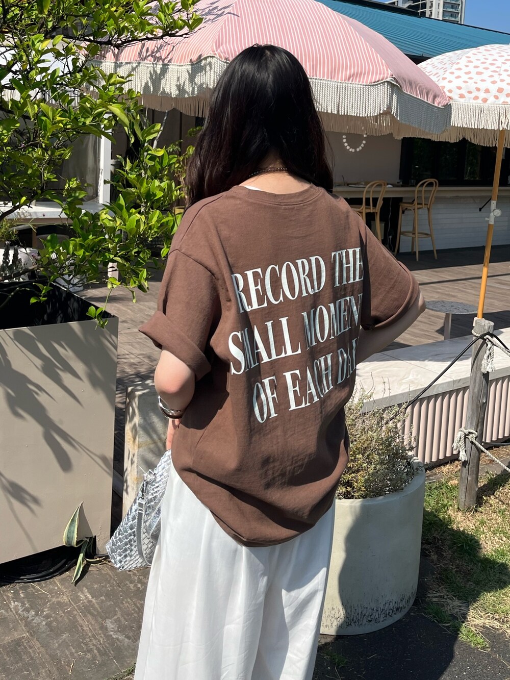 ブラウン系のTシャツ/カットソー、ホワイト系のパンツ、シルバー系のサンダルを着用したレディースの夏コーディネートの5枚目の写真