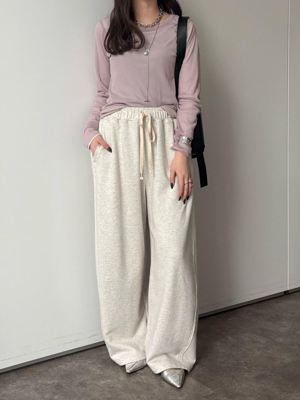グレー系のその他パンツ、グレー系のTシャツ/カットソー、シルバー系のネックレスを着用したレディースの冬コーディネートの4枚目の写真