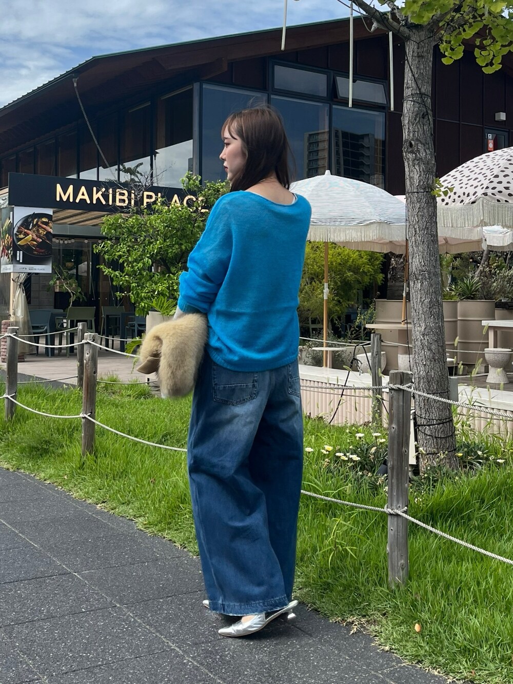 ブルー系のニット/セーター、シルバー系のTシャツ/カットソー、イエロー系のショルダーバッグを着用したレディースの秋コーディネートの2枚目の写真