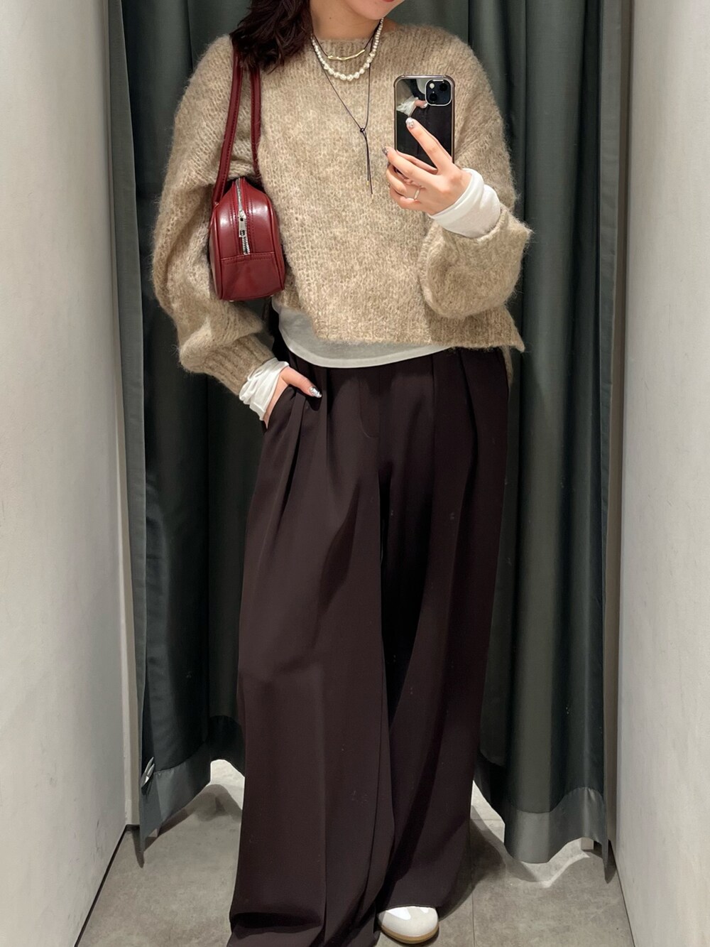 ブラウン系のスラックス、ホワイト系のスニーカー、ホワイト系のTシャツ/カットソーを着用したレディースの秋コーディネートの2枚目の写真